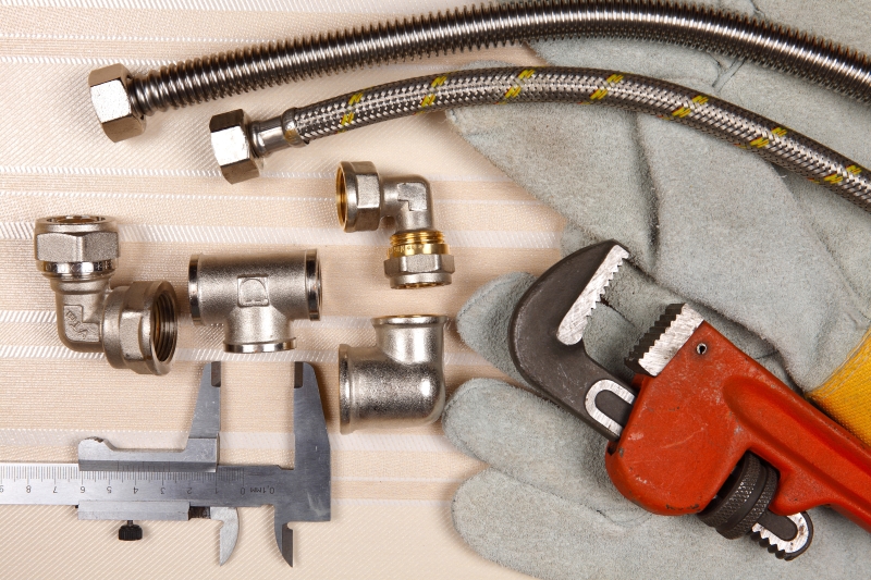 Plumber working on pipes in a West Horsley home